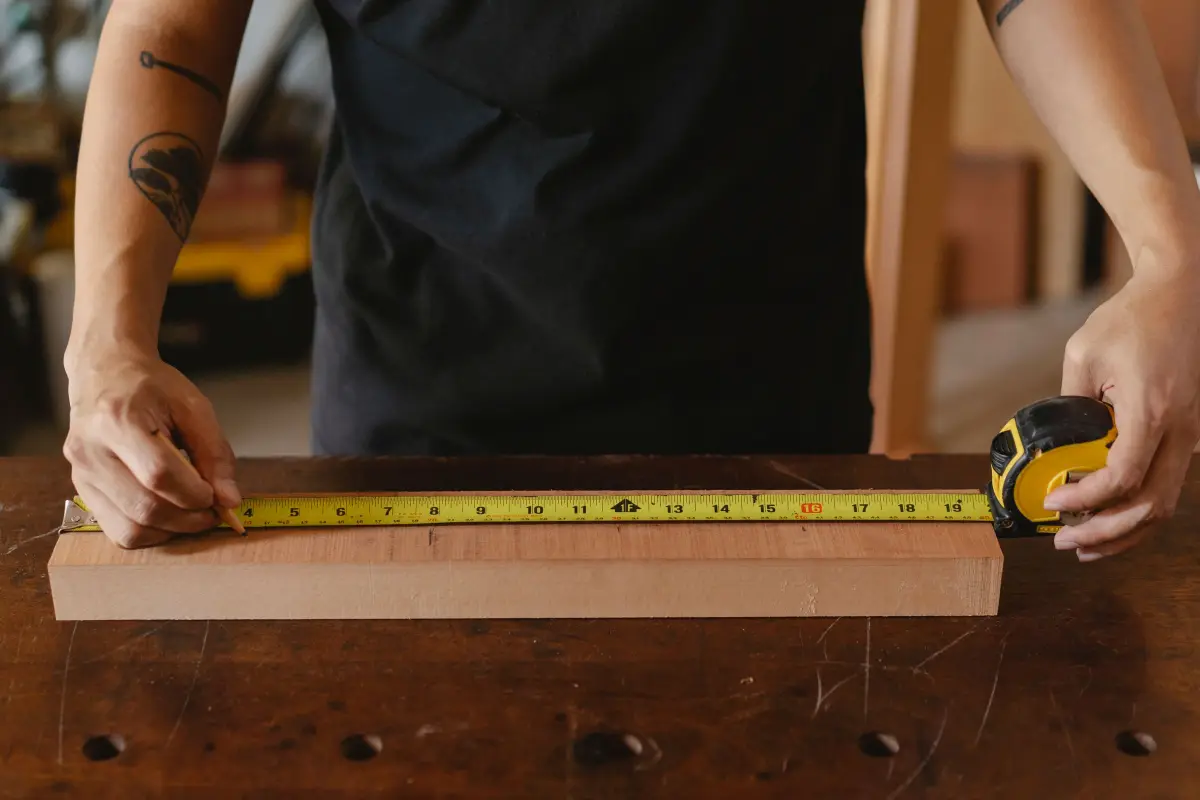 Poseur mesurant une planche de bois avant installation